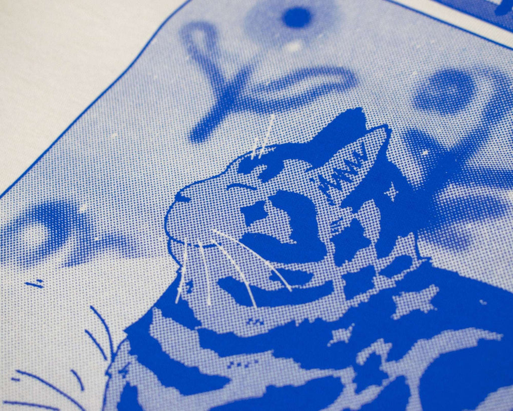 Bliss t-shirt | Hand screen printed on sand/beige organic cotton tee with blue comic style illustration of a tabby cat getting comfy