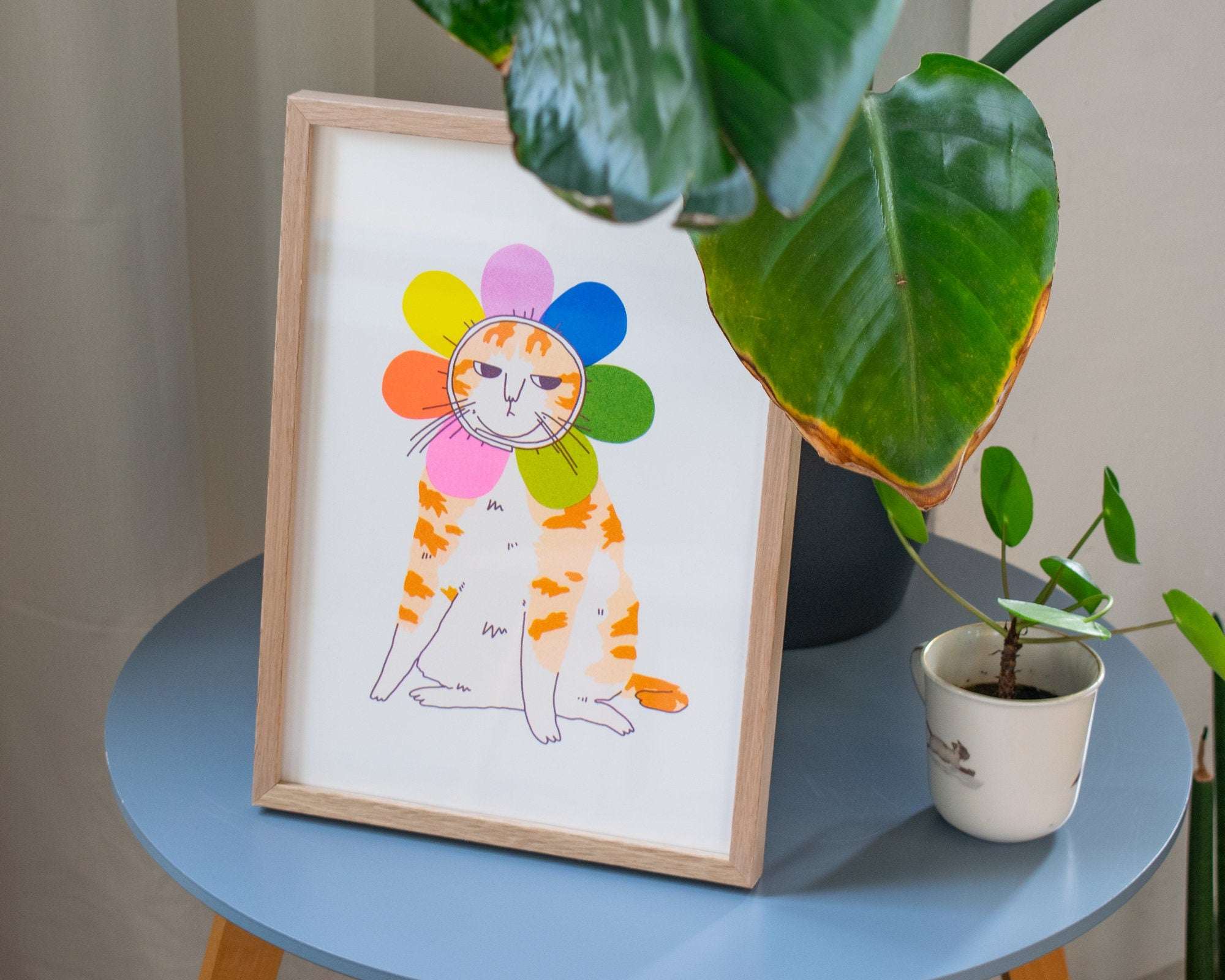 Grumpy Flower A4 Risograph poster | Illustration in fluorescent pink, blue and yellow of an angry looking cat in a flower costume