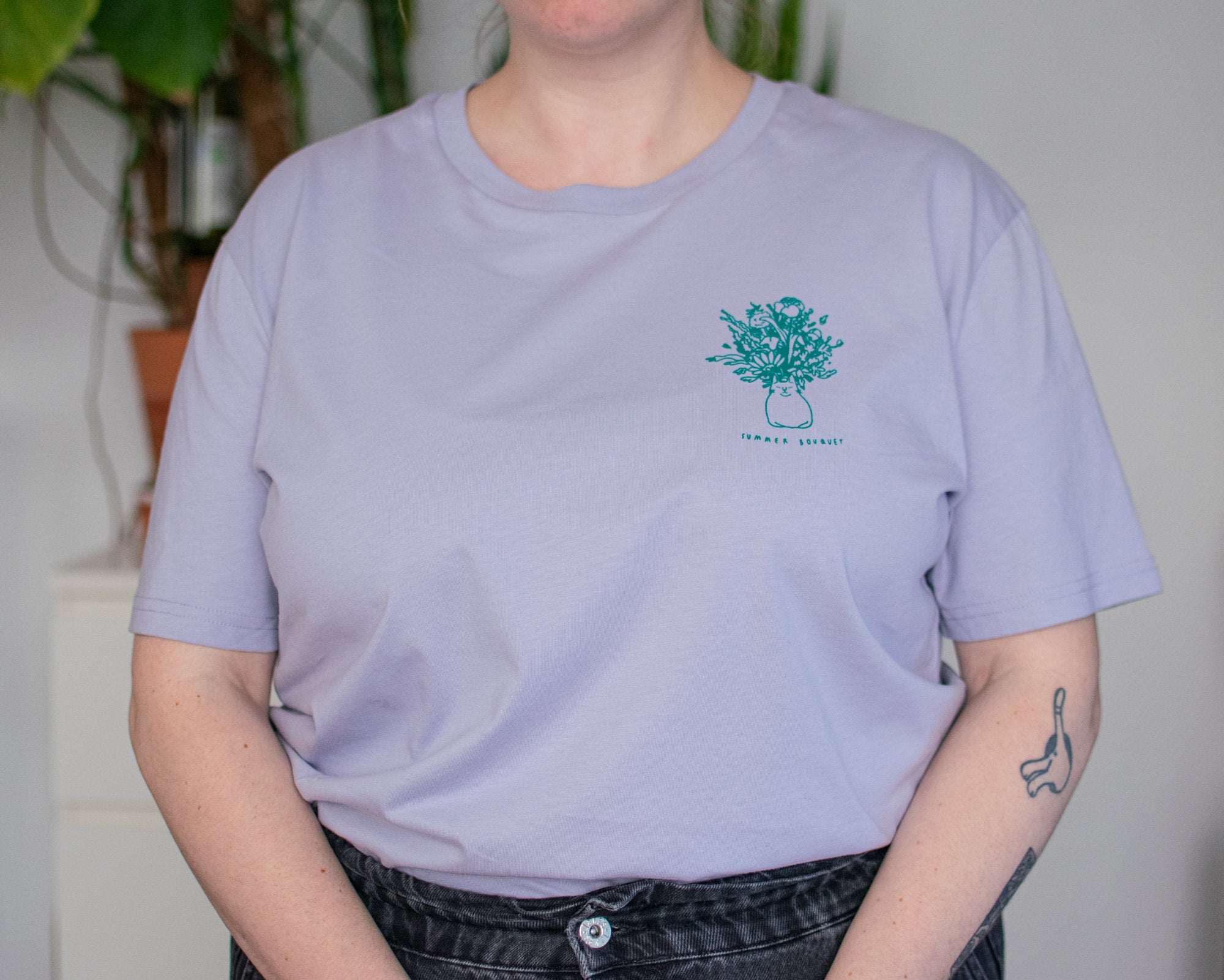 Summer Bouquet T-Shirt | Hand screen printed illustration of 7 cats with flowercrowns and other plants in green on lilac organic cotton tee
