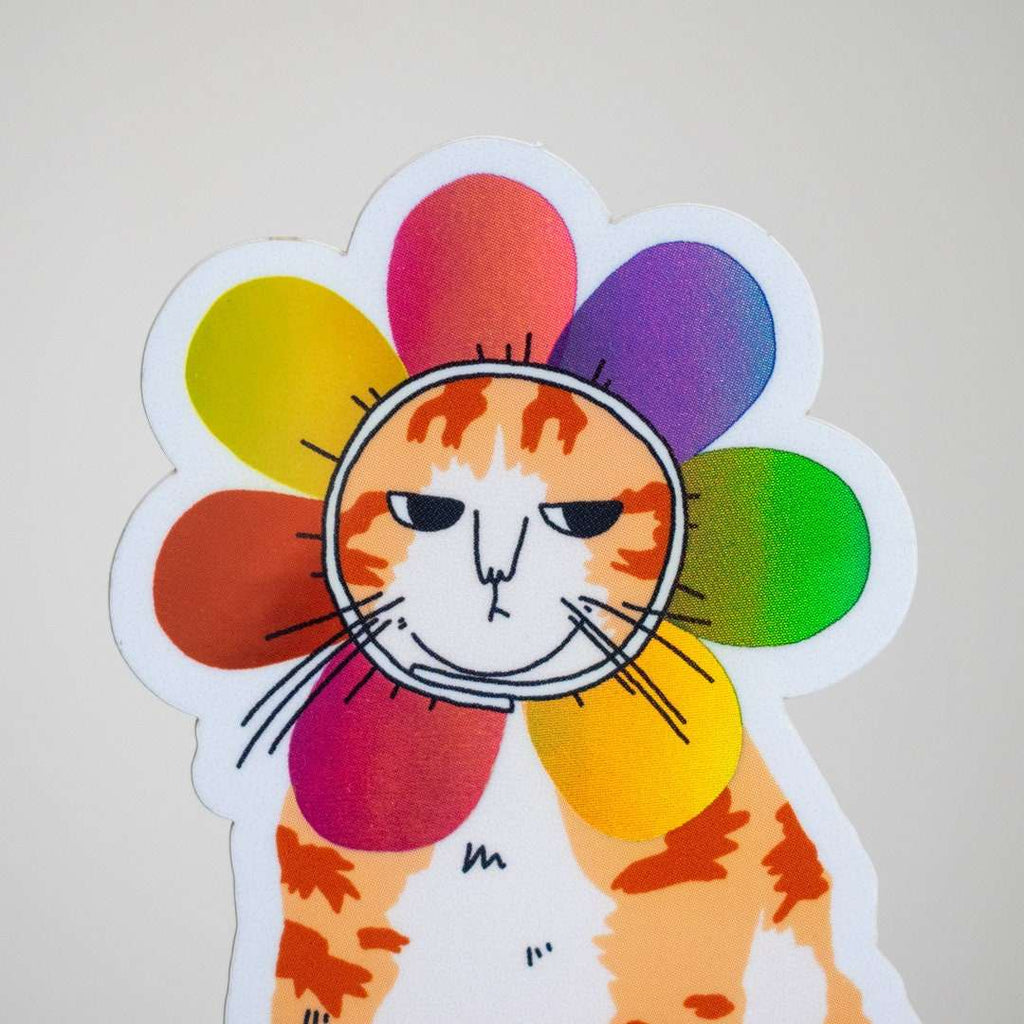 Grumpy Flower Cat | Holographic vinyl sticker of a irritable orange tabby cat wearing a rainbow colored flower petal costume around its head
