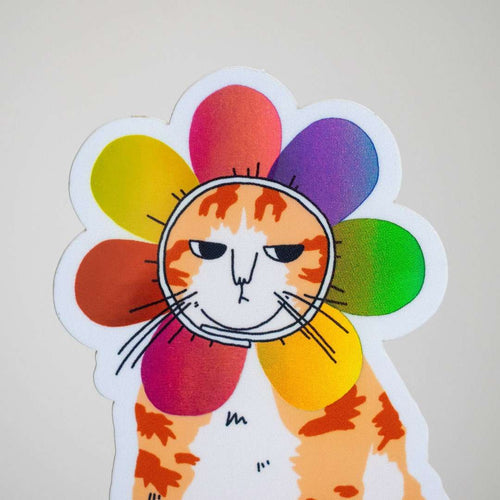 Grumpy Flower Cat | Holographic vinyl sticker of a irritable orange tabby cat wearing a rainbow colored flower petal costume around its head
