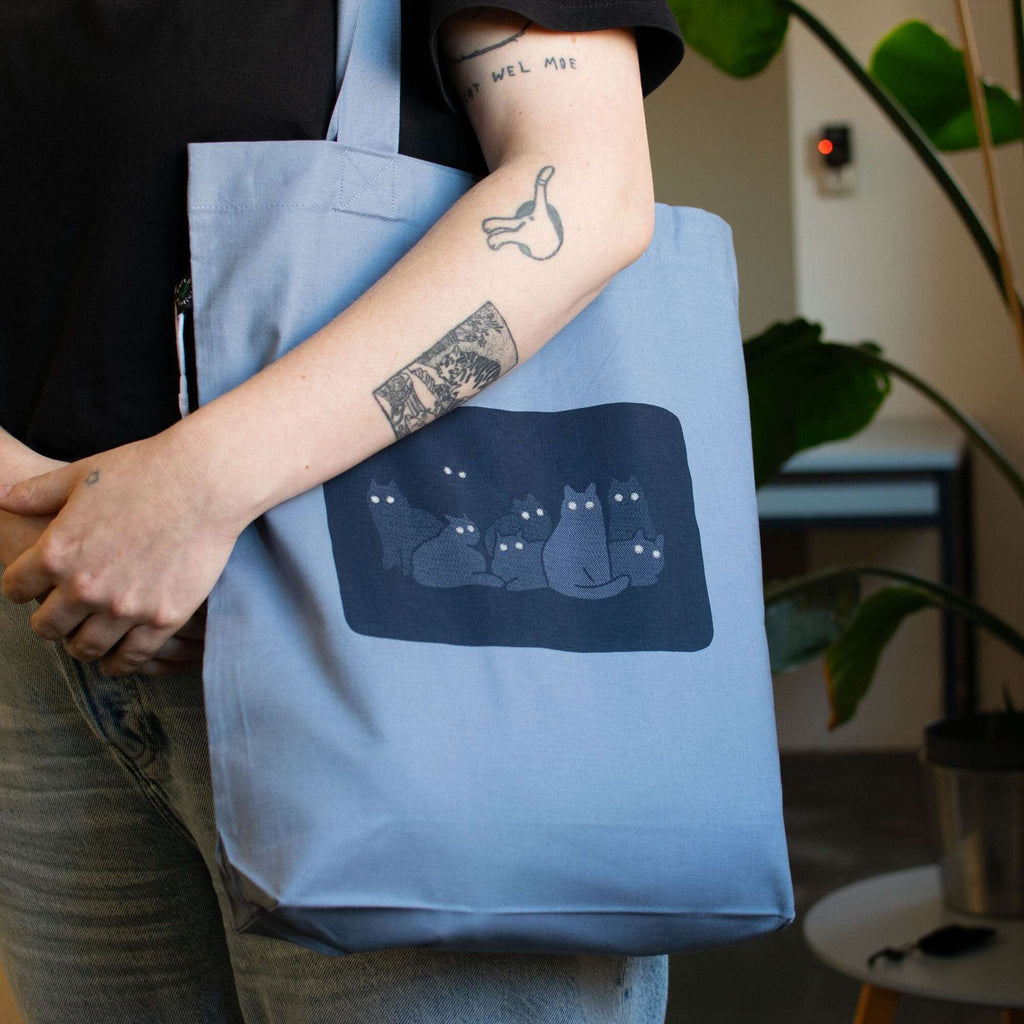 Reflecting cat eyes | Tote Bag with hand screen printed illustration of a bunch of cat silhouettes in the dark who's eyes are glowing
