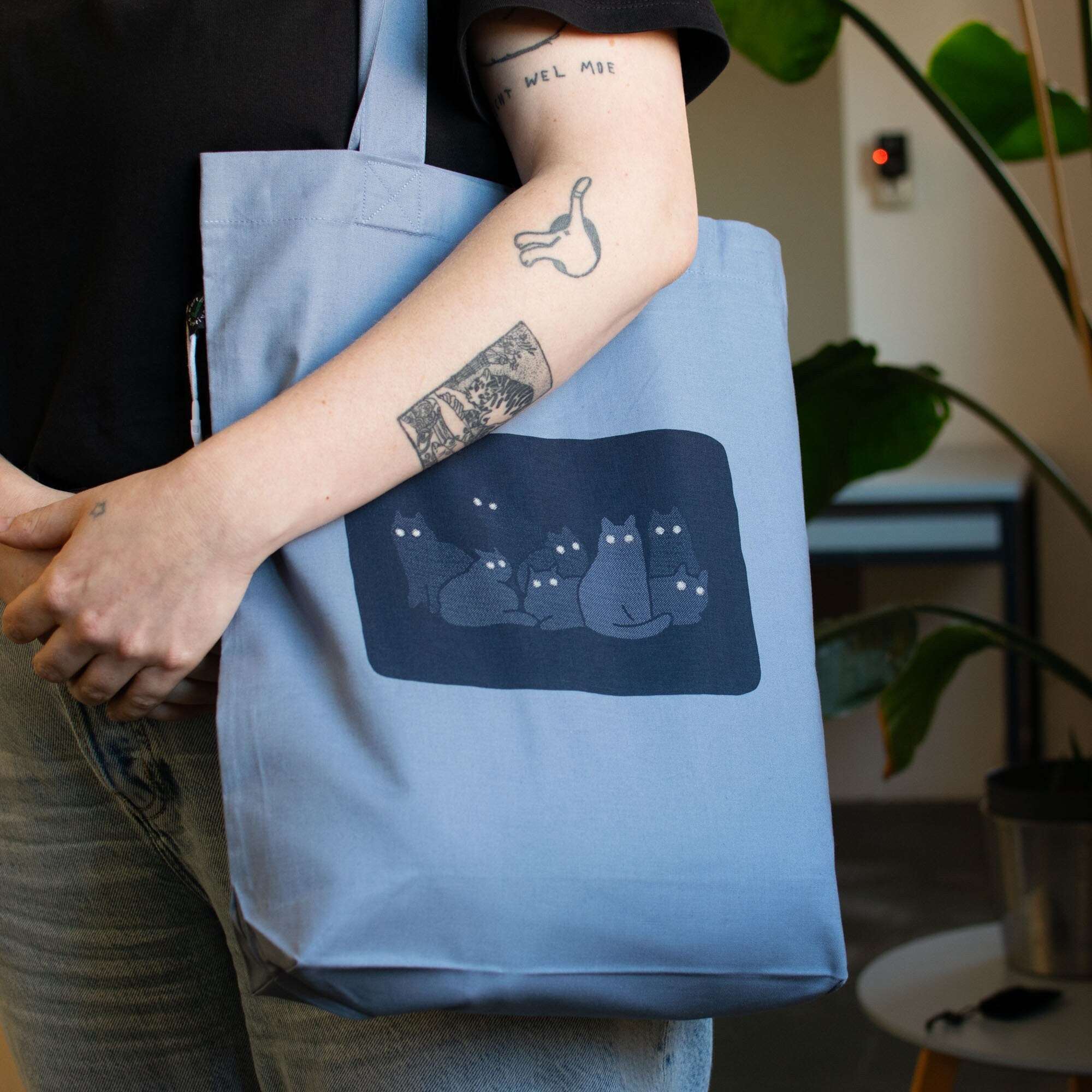 Reflecting cat eyes | Tote Bag with hand screen printed illustration of a bunch of cat silhouettes in the dark who's eyes are glowing
