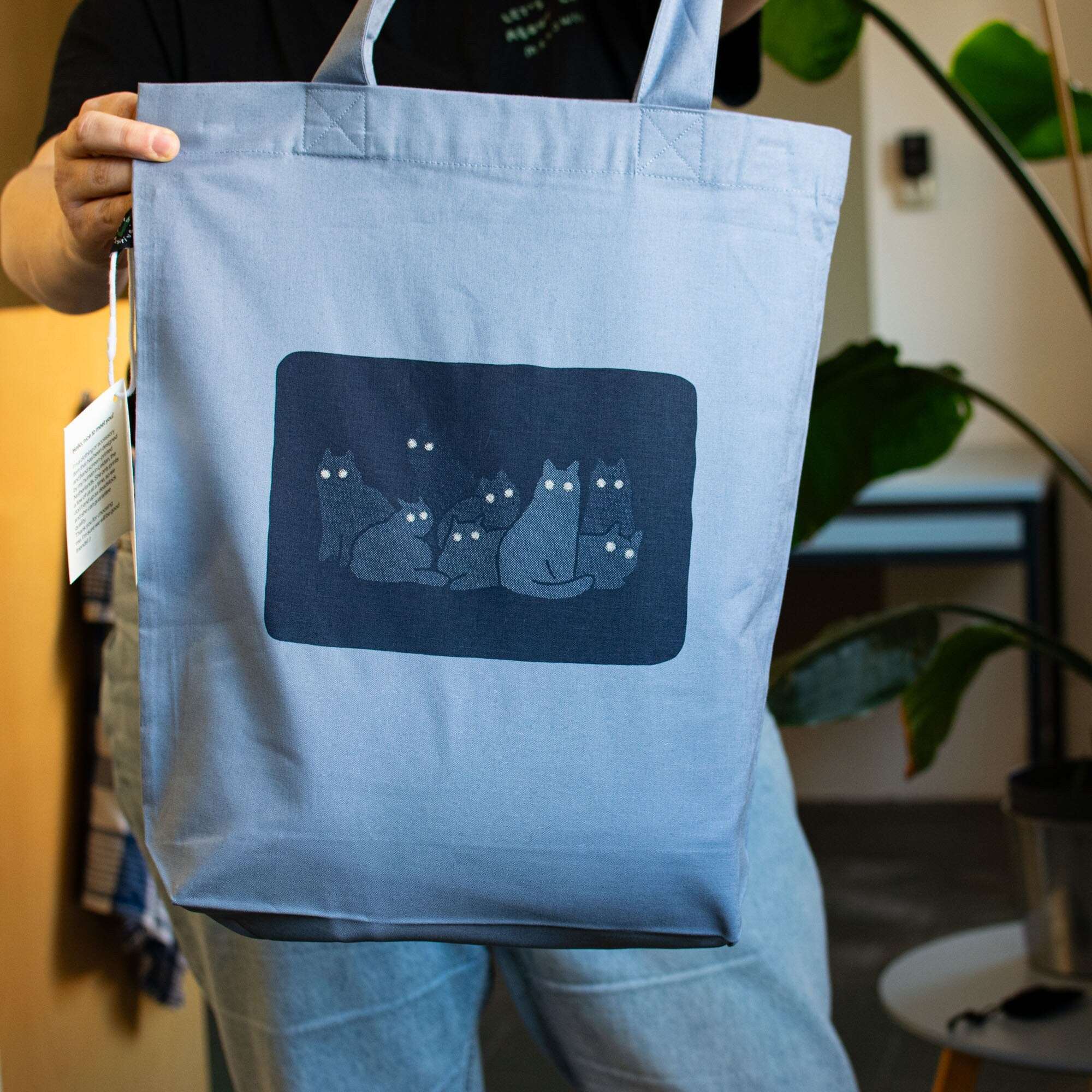 Reflecting cat eyes | Tote Bag with hand screen printed illustration of a bunch of cat silhouettes in the dark who's eyes are glowing