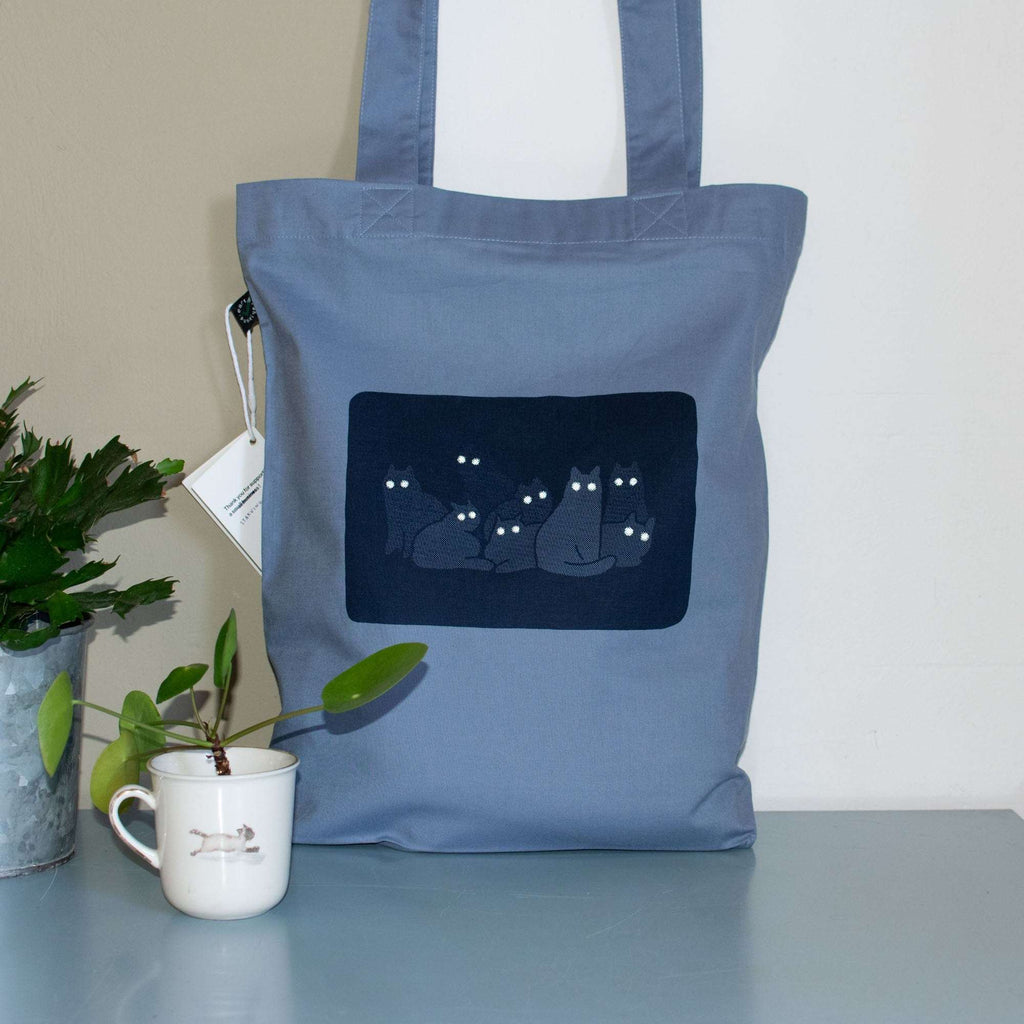 Reflecting cat eyes | Tote Bag with hand screen printed illustration of a bunch of cat silhouettes in the dark who's eyes are glowing