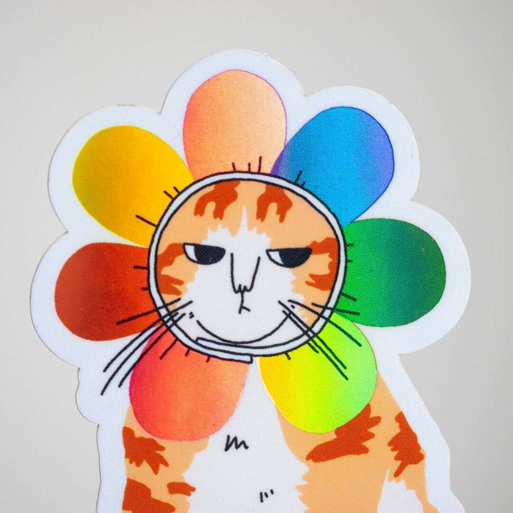 Grumpy Flower Cat | Holographic vinyl sticker of a irritable orange tabby cat wearing a rainbow colored flower petal costume around its head