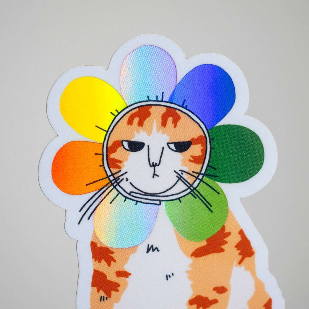 Grumpy Flower Cat | Holographic vinyl sticker of a irritable orange tabby cat wearing a rainbow colored flower petal costume around its head