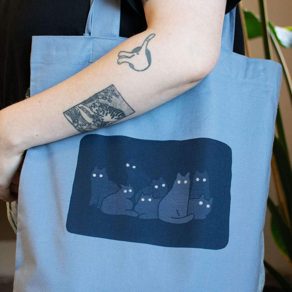 Reflecting cat eyes | Tote Bag with hand screen printed illustration of a bunch of cat silhouettes in the dark who's eyes are glowing