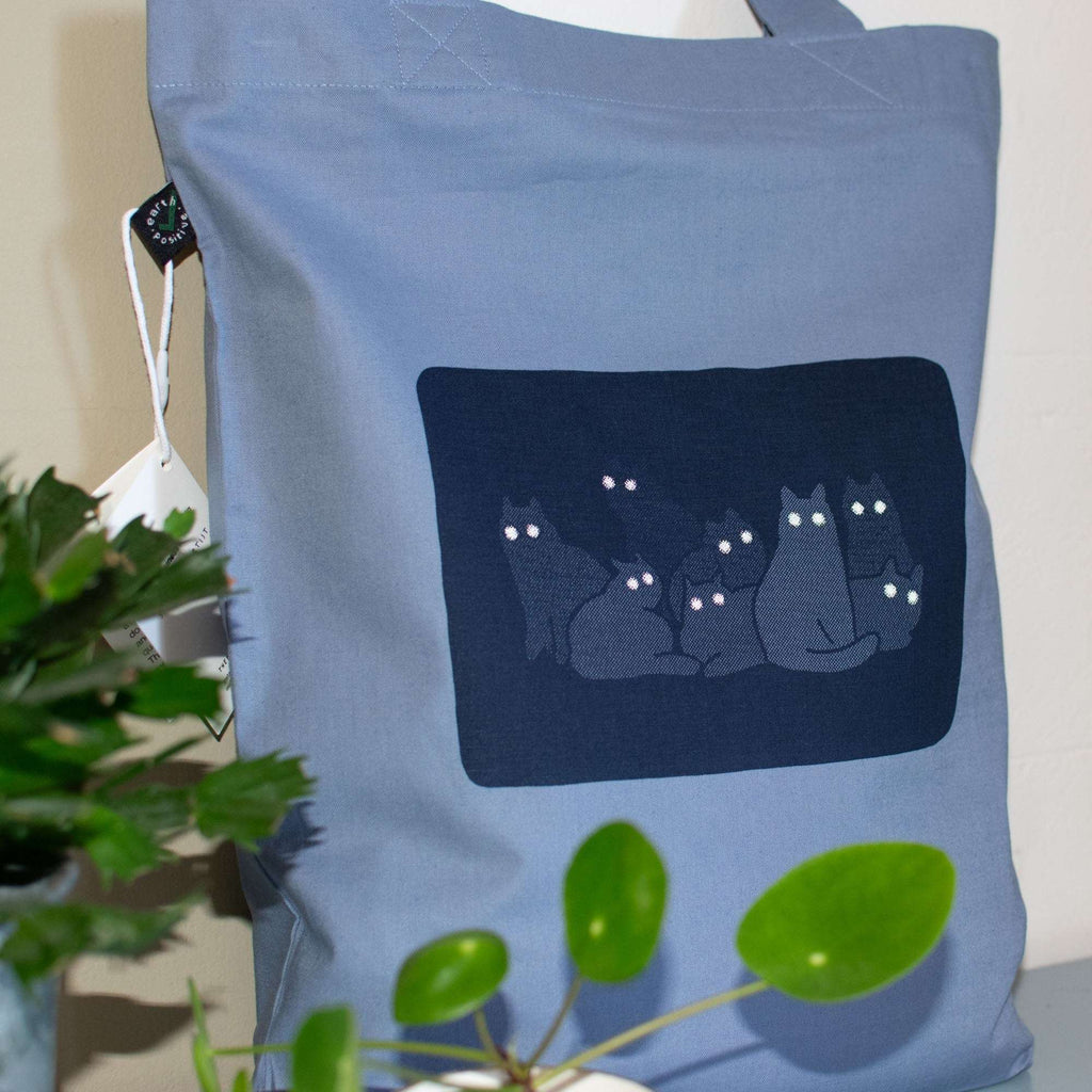 Reflecting cat eyes | Tote Bag with hand screen printed illustration of a bunch of cat silhouettes in the dark who's eyes are glowing