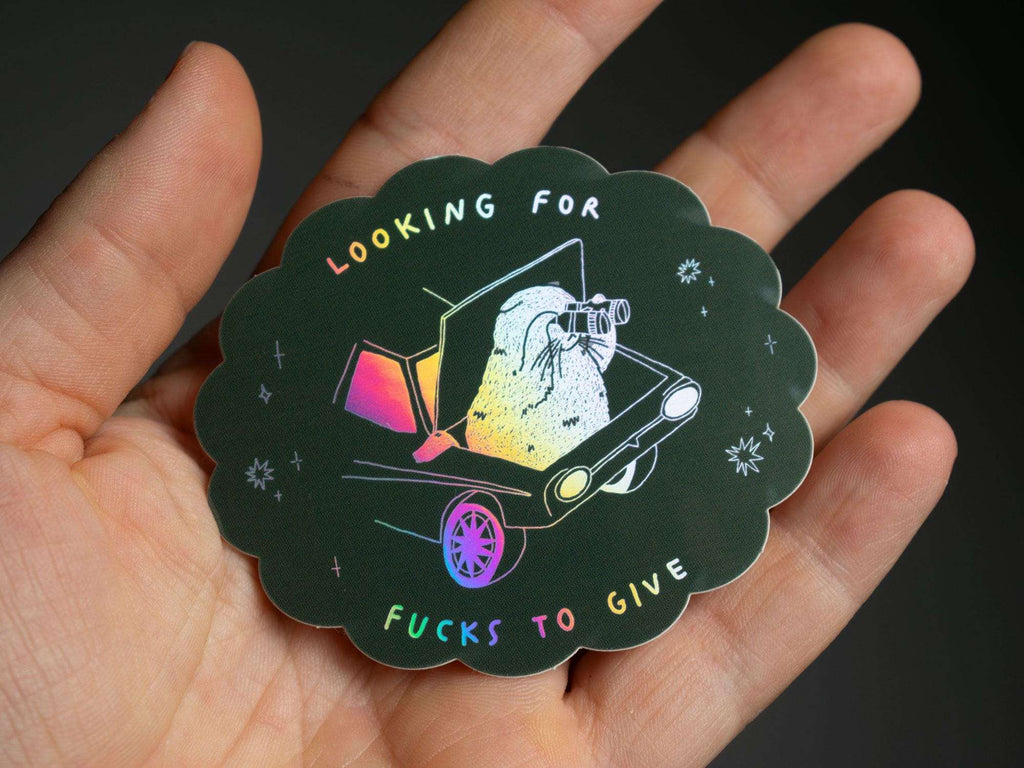 Looking for fucks to give 2.0 | Holographic Cat Sticker of a cat sitting in the trunk of a car looking for f***s to give through binoculars