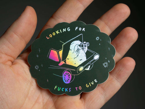 Looking for fucks to give 2.0 | Holographic Cat Sticker of a cat sitting in the trunk of a car looking for f***s to give through binoculars
