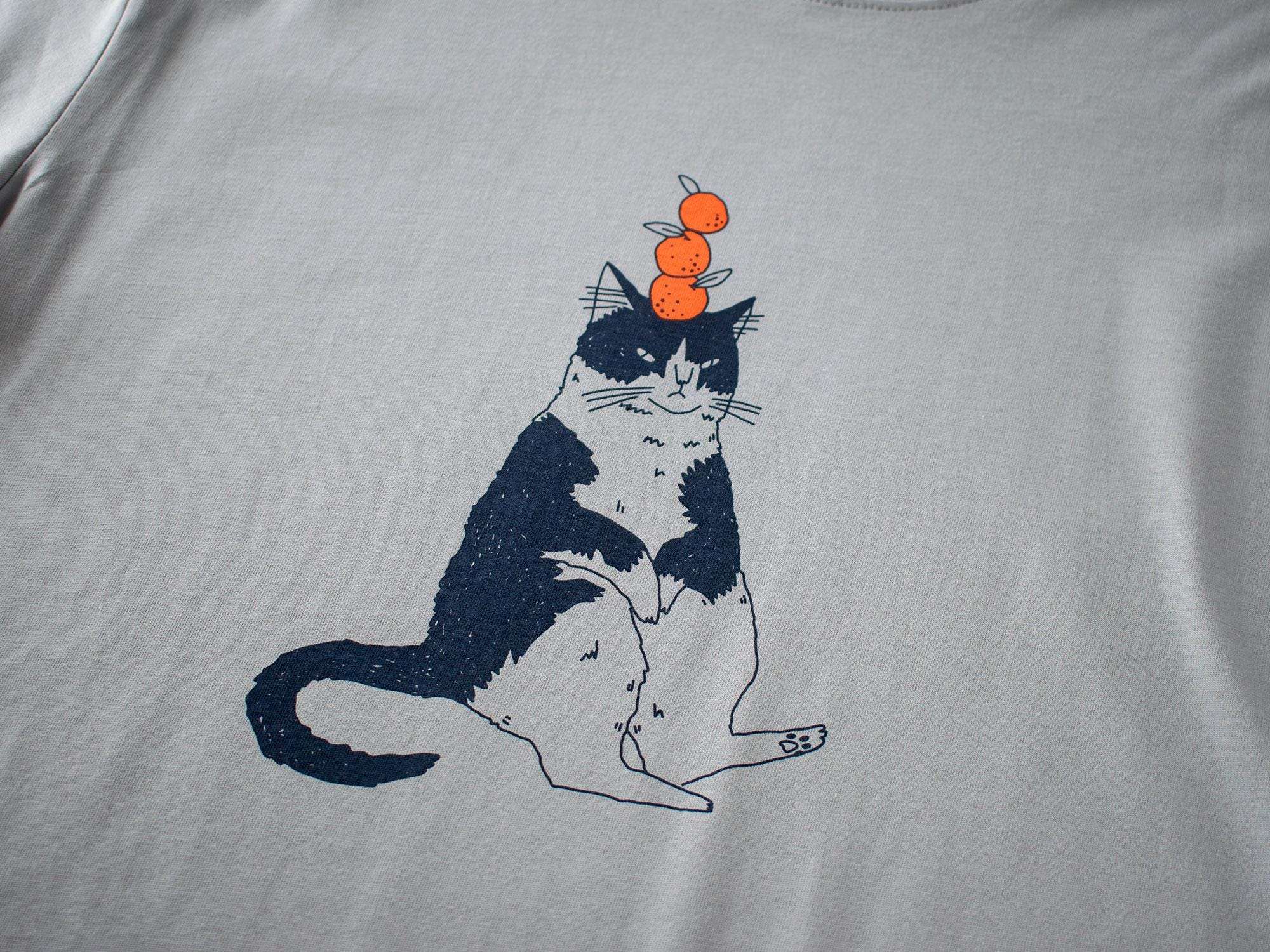 Orange Cat t-shirt | Hand screen printed illustration of a cat balancing oranges on grey organic cotton tee with navy and orange