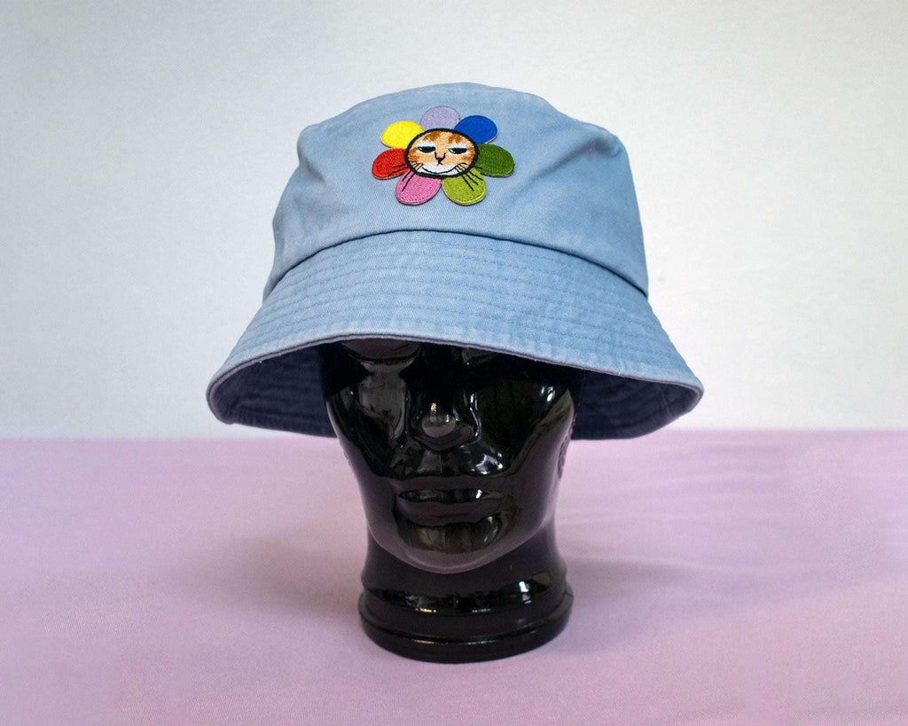 Grumpy Flower Bucket Hat | Sky blue fishermans hat with dtf printed or embroiderd patch of a grumpy cat with rainbow flower around is neck
