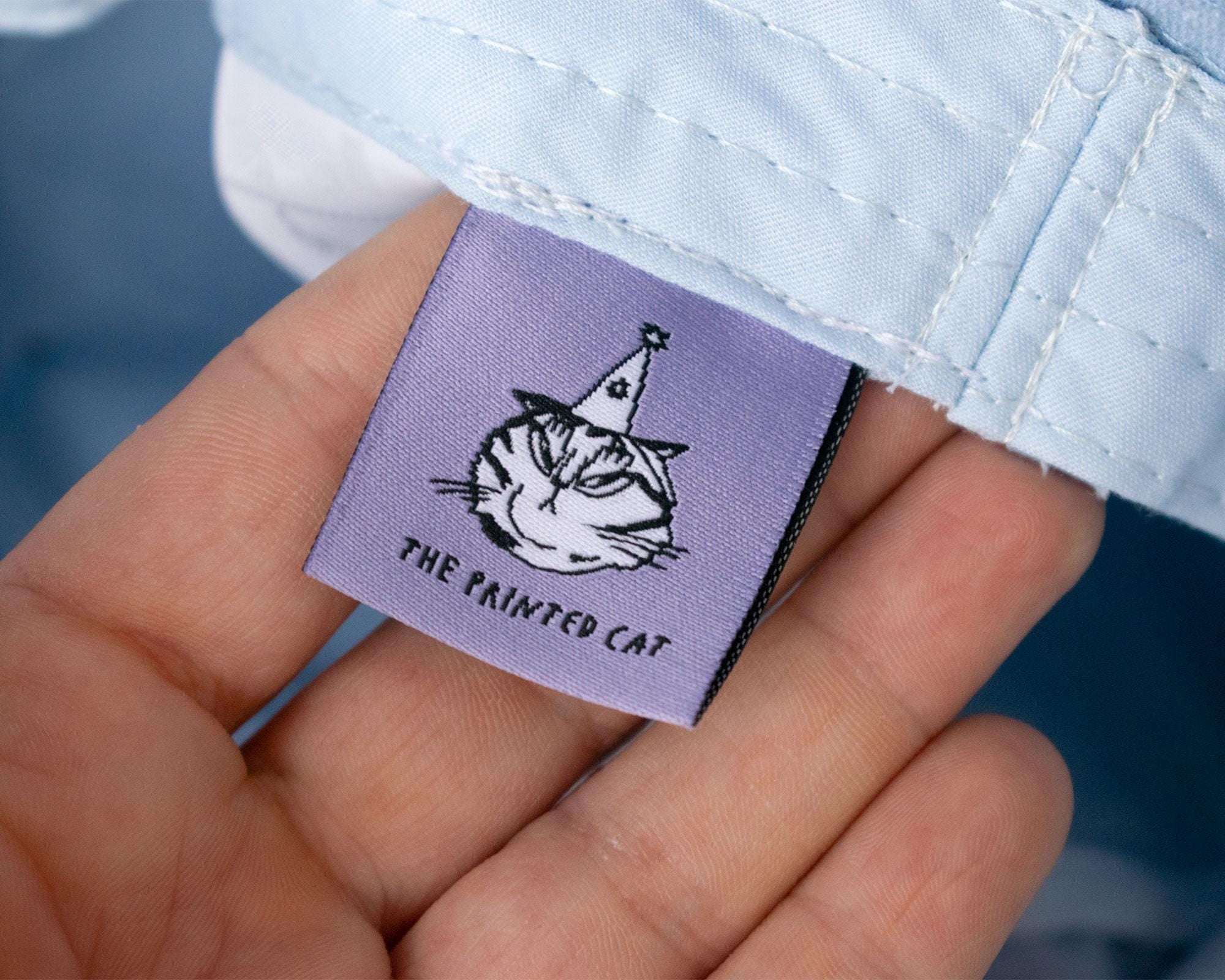 Grumpy Flower Bucket Hat | Sky blue fishermans hat with dtf printed or embroiderd patch of a grumpy cat with rainbow flower around is neck