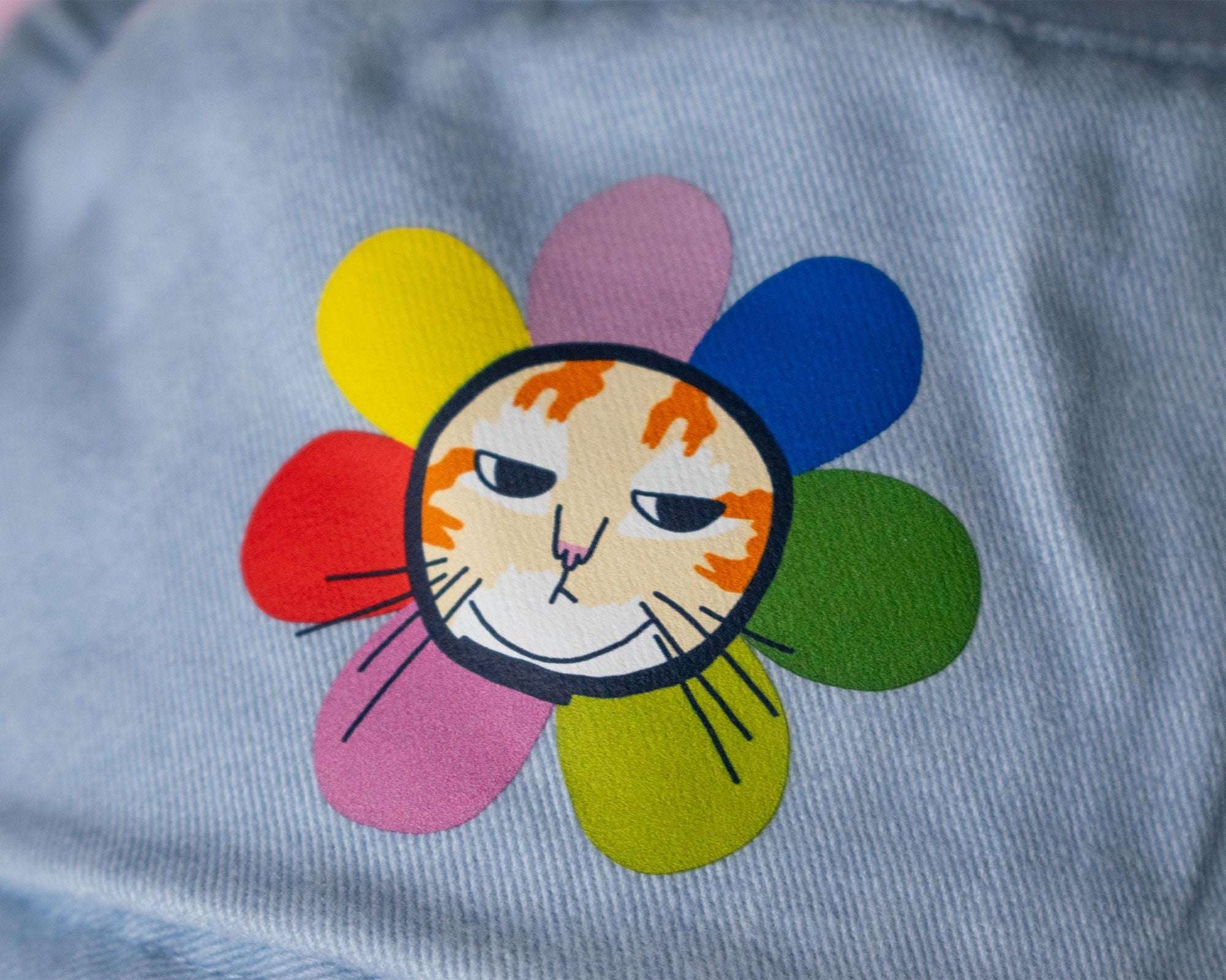 Grumpy Flower Bucket Hat | Sky blue fishermans hat with dtf printed or embroiderd patch of a grumpy cat with rainbow flower around is neck