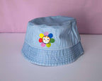 Grumpy Flower Bucket Hat | Sky blue fishermans hat with dtf printed or embroiderd patch of a grumpy cat with rainbow flower around is neck