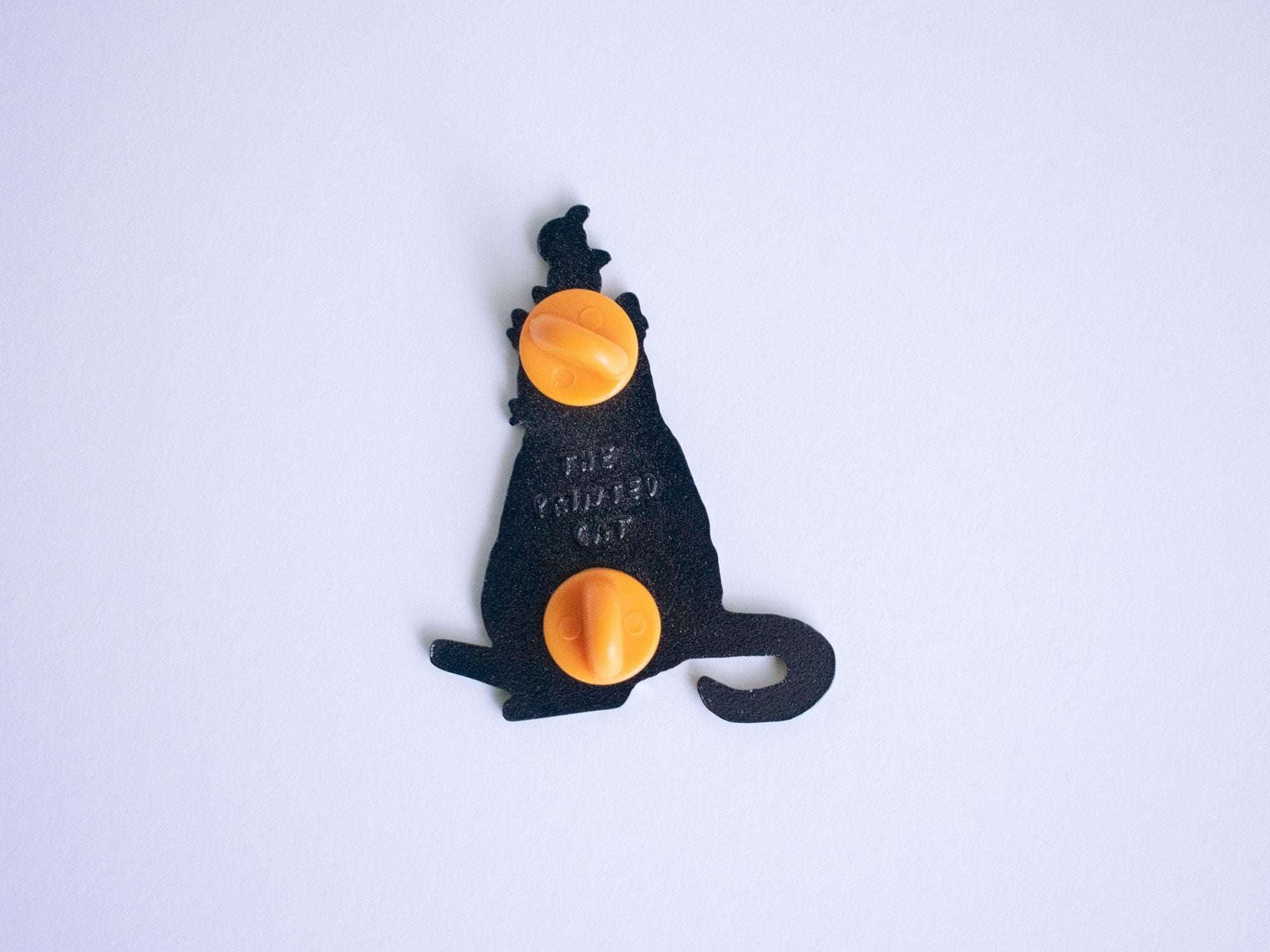 Orange Balance Cat Enamel Pin | Black nickel plated brooch with a tuxedo cat balancing three oranges on its head