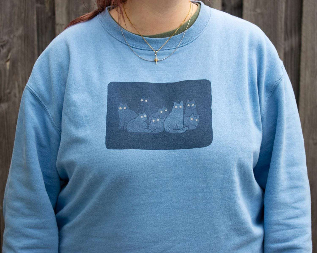 Reflecting eyes sweatshirt with a hand screen printed illustration of a bunch of cats in the dark