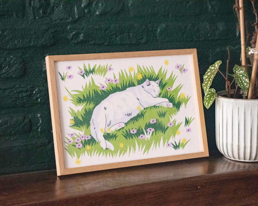 Garden sleeps | Giclée art print for outdoor lovers of a white cat sleeping on grass with flowers surrounding it