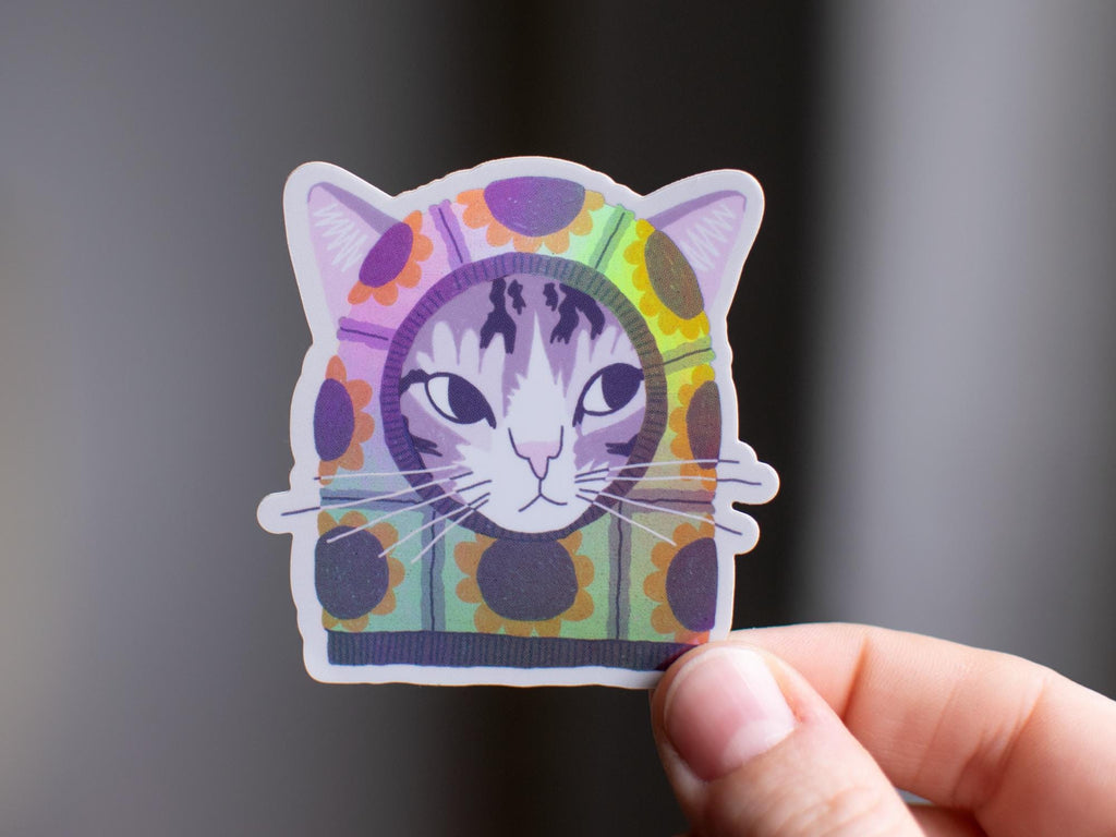 Sunflower Balaclava Cat | Cute holographic vinyl sticker of a purple tabby cat wearing a balaclava with flowers on it