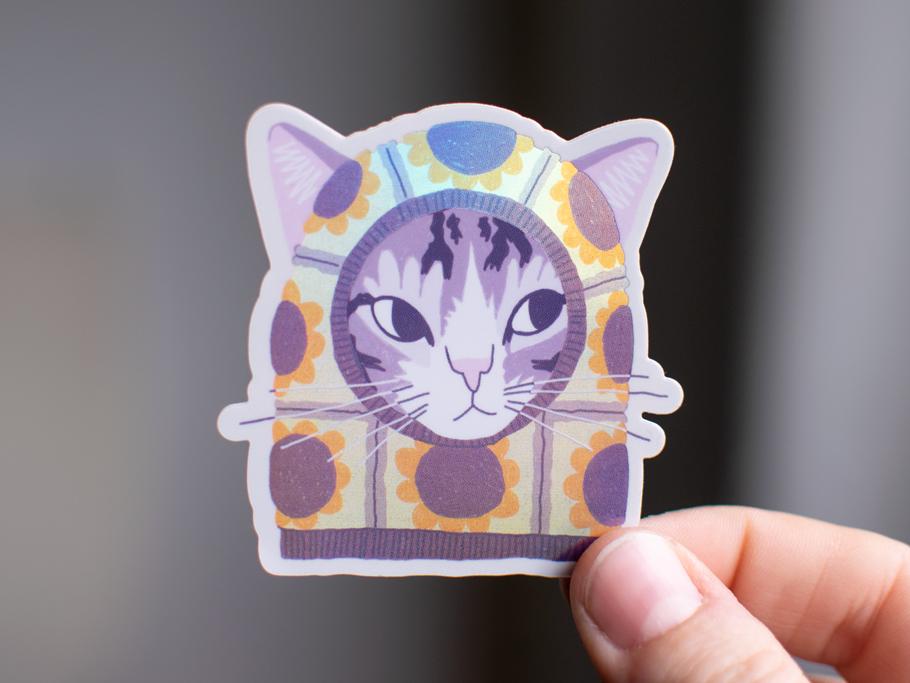 Sunflower Balaclava Cat | Cute holographic vinyl sticker of a purple tabby cat wearing a balaclava with flowers on it