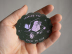Looking for fucks to give 2.0 | Holographic Cat Sticker of a cat sitting in the trunk of a car looking for f***s to give through binoculars