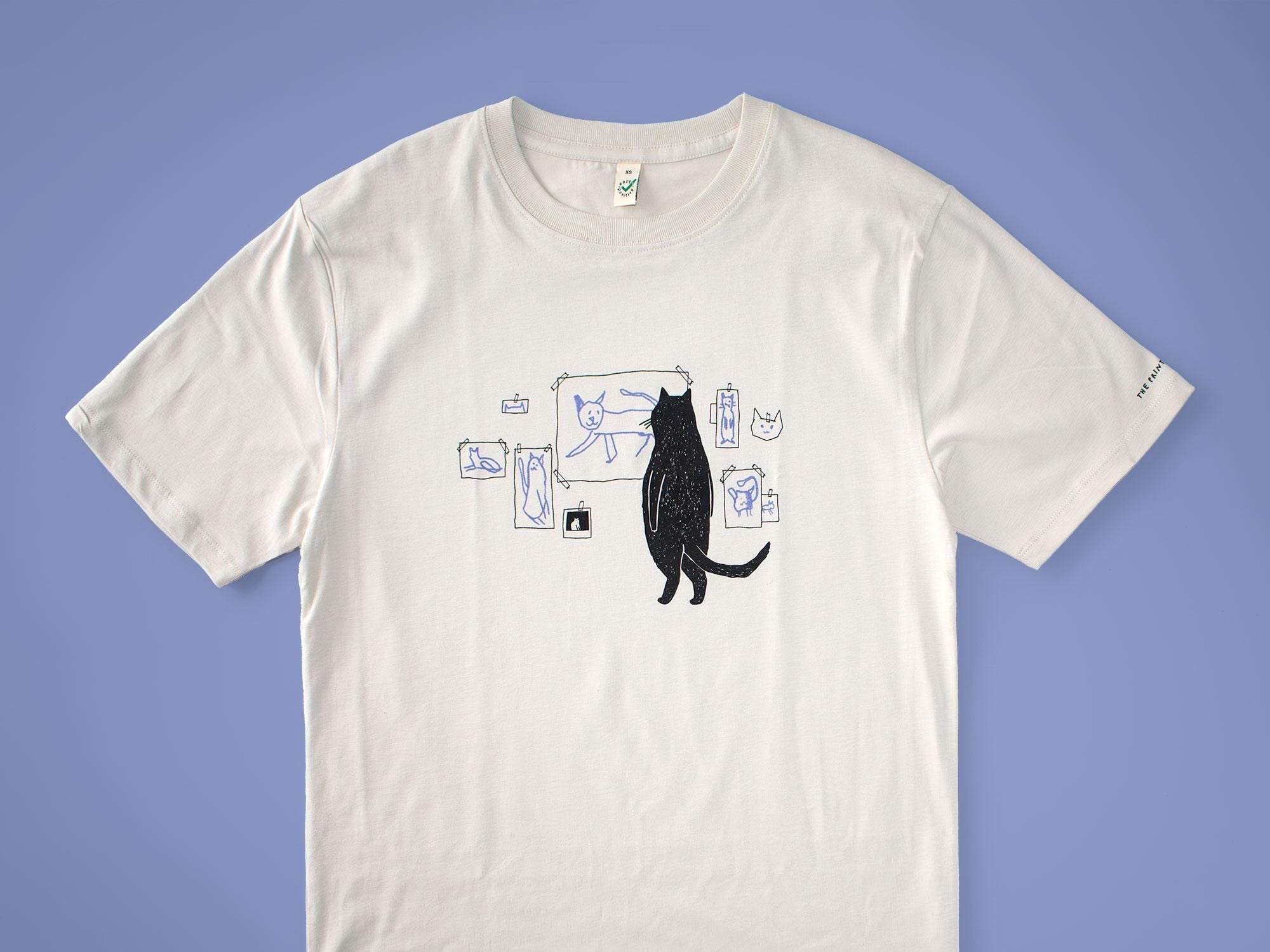 Cat gallery t-shirt | Hand screen printed on beige organic cotton tee with black and blue illustration of a cat judging his own art
