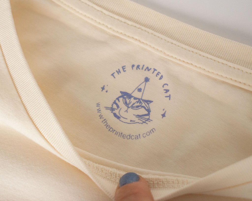 Cat gallery top | Hand screen printed on ecru organic cotton sleevless cropped top with black and blue illustration of a cat judging cat art