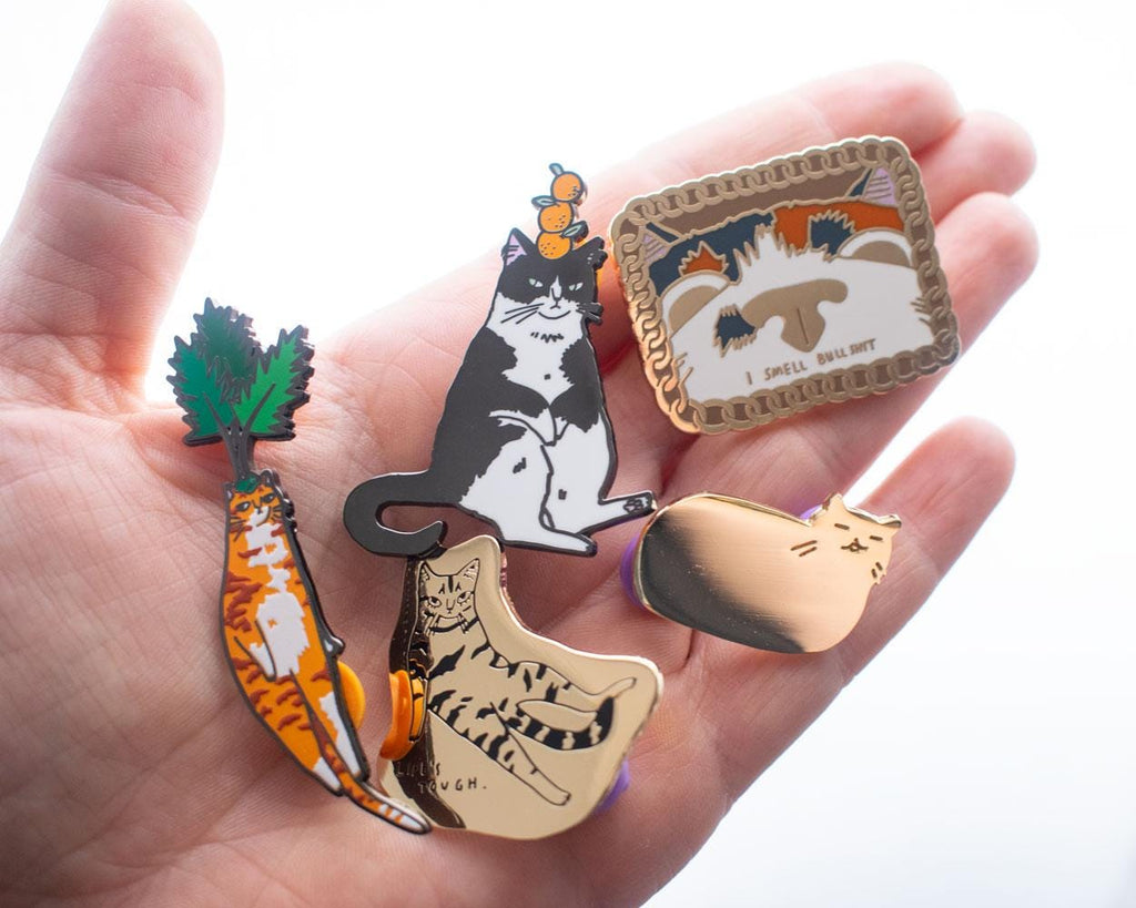 Orange Balance Cat Enamel Pin | Black nickel plated brooch with a tuxedo cat balancing three oranges on its head
