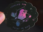 Looking for fucks to give 2.0 | Holographic Cat Sticker of a cat sitting in the trunk of a car looking for f***s to give through binoculars