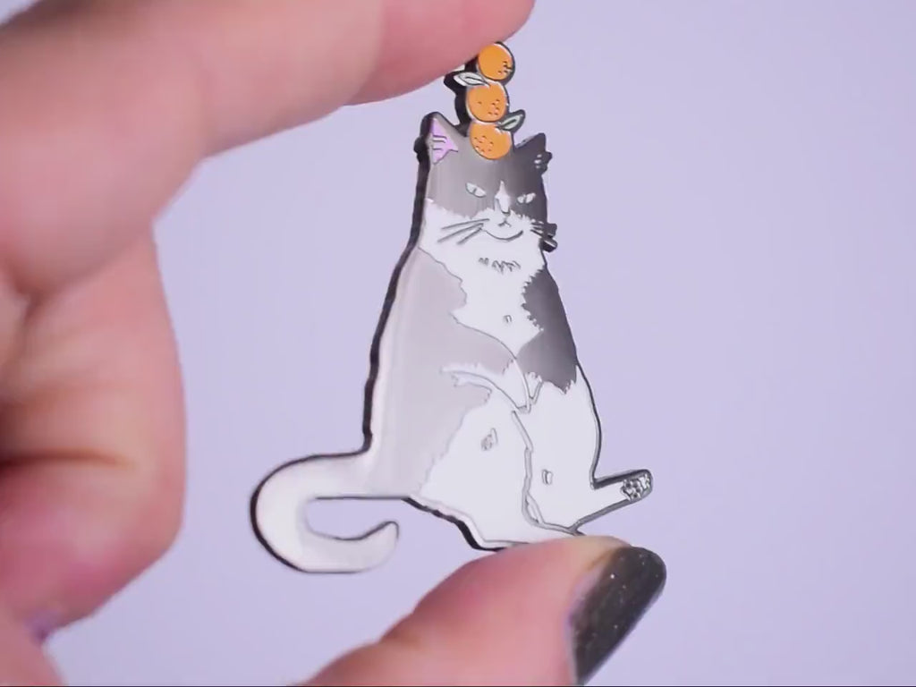 Orange Balance Cat Enamel Pin | Black nickel plated brooch with a tuxedo cat balancing three oranges on its head